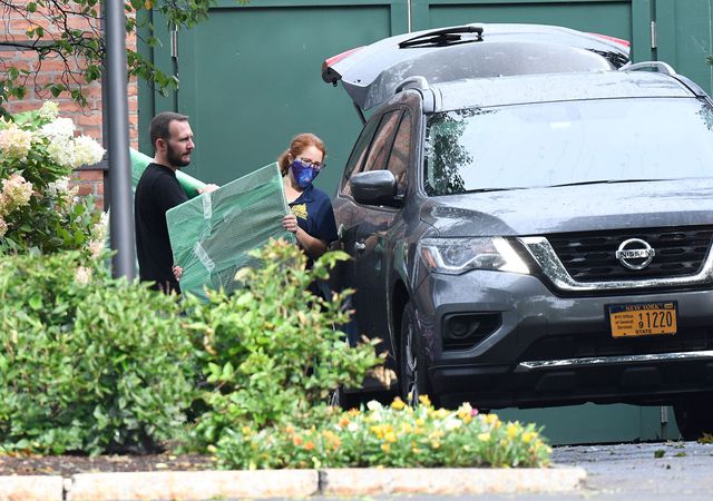 Employees from the state office of general services are seen moving items into an SUV outside the Governor's mansion